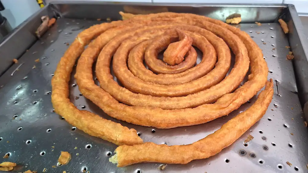 
    Foto
    de
    una
    rueda
    de
    churros
    y
    un
    vaso
    de
    chocolate